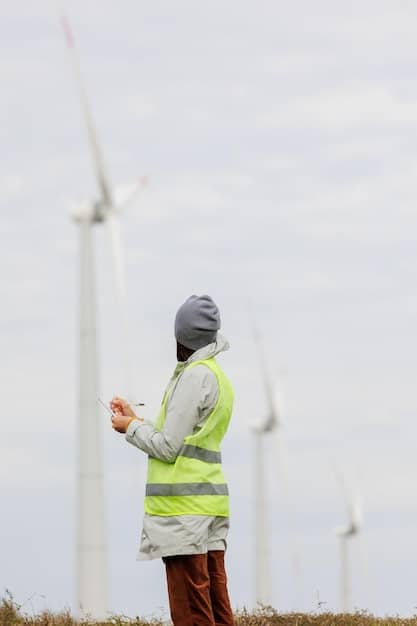 A close-up shot of a technician inspecting the blades of a wind turbine in a wind farm, highlighting the technical skills required for maintenance roles in the wind energy sector.