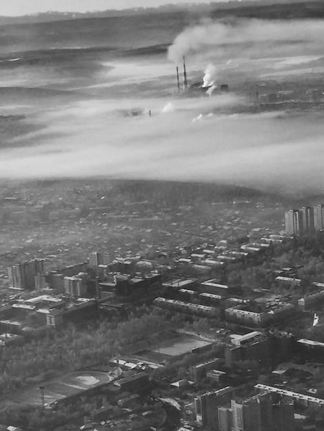 A stark image depicting a polluted cityscape with heavy smog and industrial smoke billowing into the atmosphere. The photo conveys the detrimental effects of burning fossil fuels and highlights the urgent need for cleaner energy alternatives.