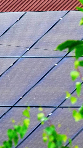 A close-up of a solar panel installation on a residential rooftop, highlighting the individual panels and their mounting hardware. The image captures the detailed craftsmanship and precision of the installation, with a focus on the technical aspects of solar energy integration.