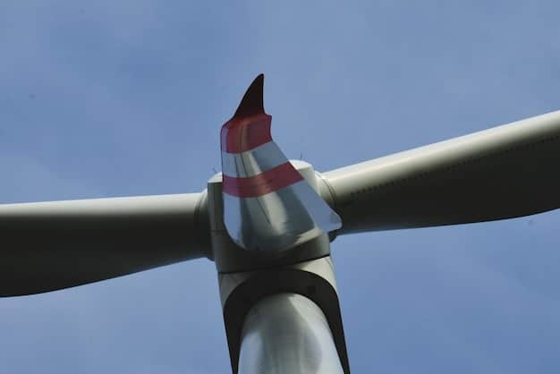A close-up shot of a wind turbine blade made from advanced composite materials. The blade is textured and shows the intricate layering of the materials, highlighting the durability and lightweight properties essential for efficient energy capture.