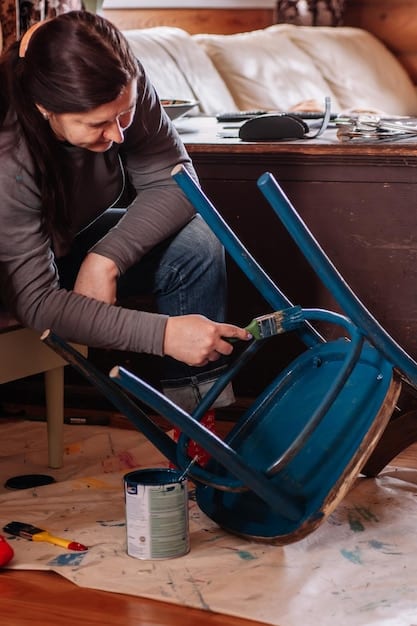 A person skillfully repairing a small piece of furniture with basic tools. The image highlights the hands-on process, showing the individual carefully sanding a wooden leg. The tools should appear simple and accessible, encouraging the idea that DIY repairs are within anyone's reach.