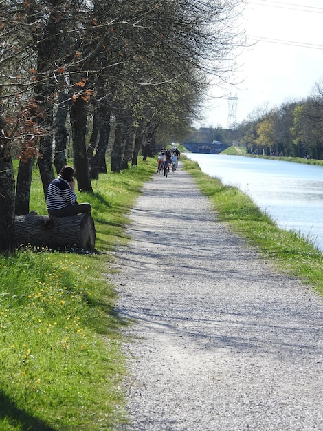 A well-maintained bike path alongside a tranquil river, with cyclists enjoying the scenery and promoting eco-friendly commuting.