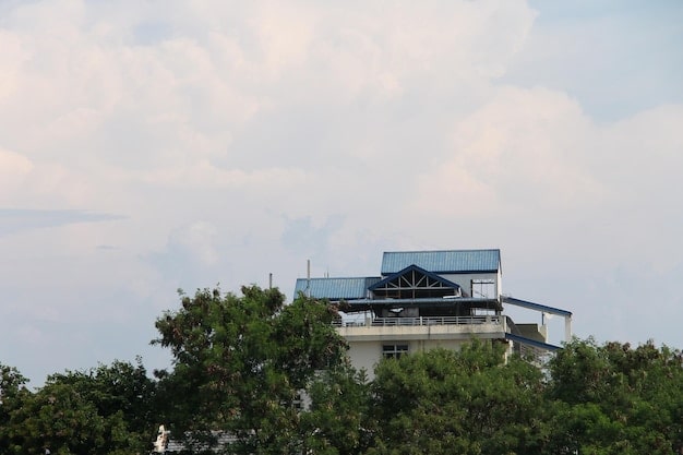 A modern house with sleek solar panels integrated into the roof, set against a partly cloudy sky.