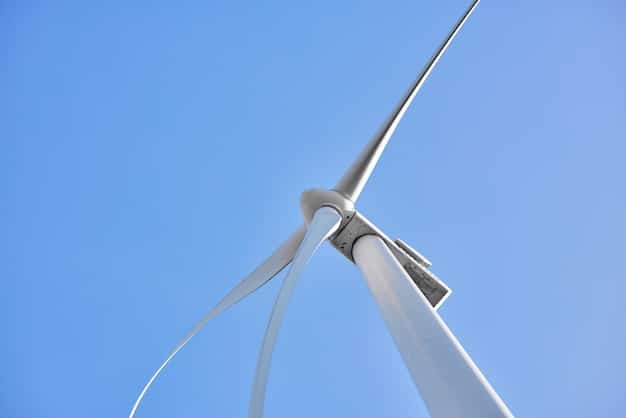 Close-up view of the base of a massive, next-generation wind turbine. The focus is on the immense scale of the structure and the engineering involved. The background includes workers in hard hats, suggesting ongoing construction or maintenance.