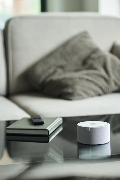 A close-up of a smart thermostat installed in a modern home, displaying energy consumption data. The background shows a comfortable living room setting.