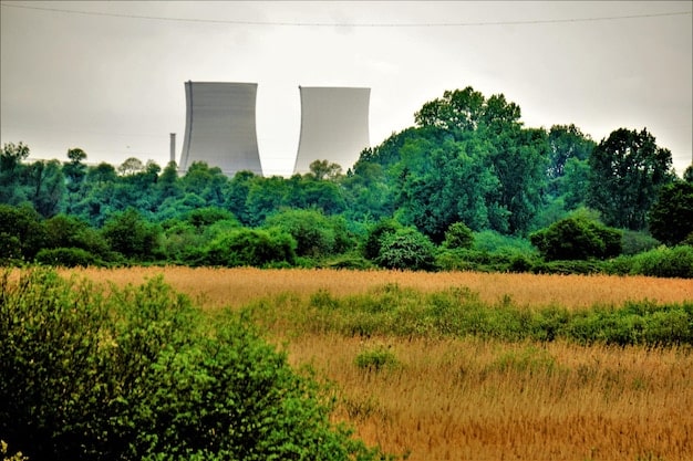 A split-screen image showing, on one side, a traditional industrial area with smokestacks, and on the other side, a clean, futuristic green hydrogen production facility with lush greenery.