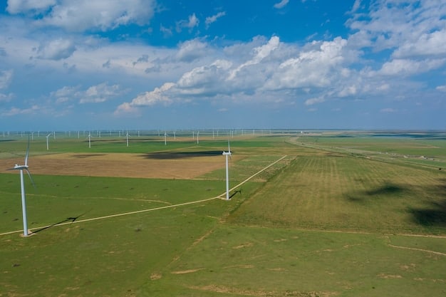 An aerial view of a wind farm located in a grassland area, showing the network of access roads between turbines and substations. The image illustrates how wind energy infrastructure can impact the natural landscape and potentially fragment habitats.