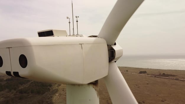 A close-up aerial view of a wind turbine installation vessel deploying a massive turbine blade at an offshore wind farm. The sea is calm and the sky is clear, highlighting the scale of the operation.