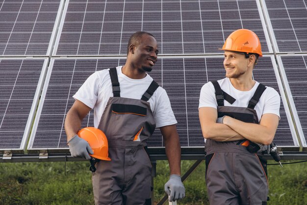A diverse group of workers installing solar panels on a rooftop, with a city skyline in the background.